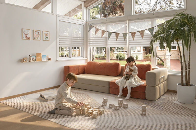 Children playing on modular kids play sofa in cream and orange colors – CushyLand by Acanva 13