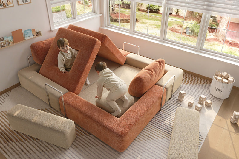 Children playing on modular kids play sofa in cream and orange colors – CushyLand by Acanva 1